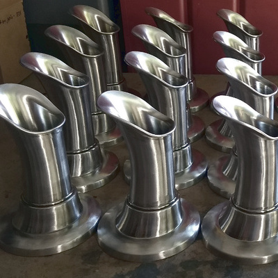 A bunch of Oona fountain spouts made of polished stainless steel