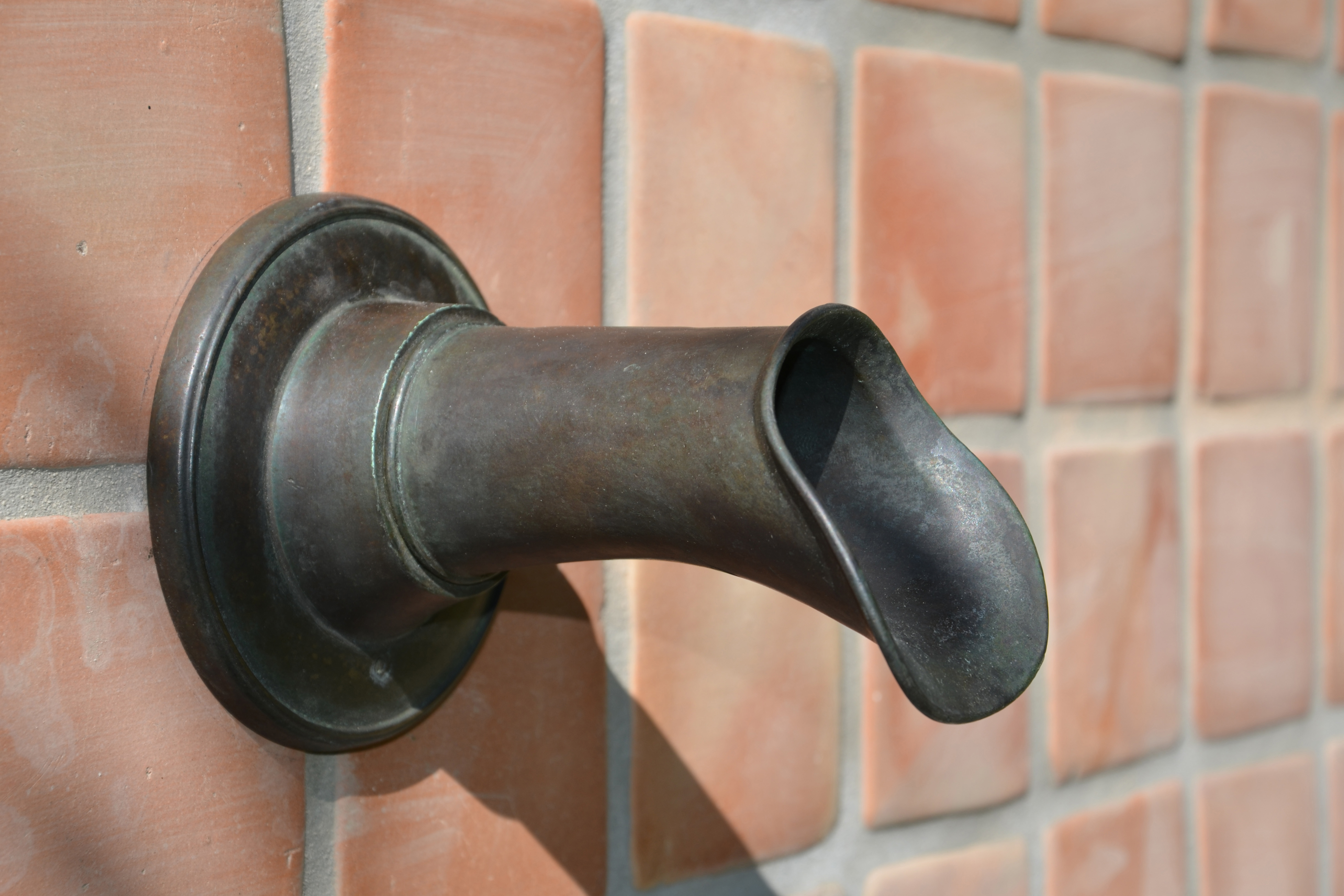 The Oona: a bronze fountain spout with a round cross section and elegant flare