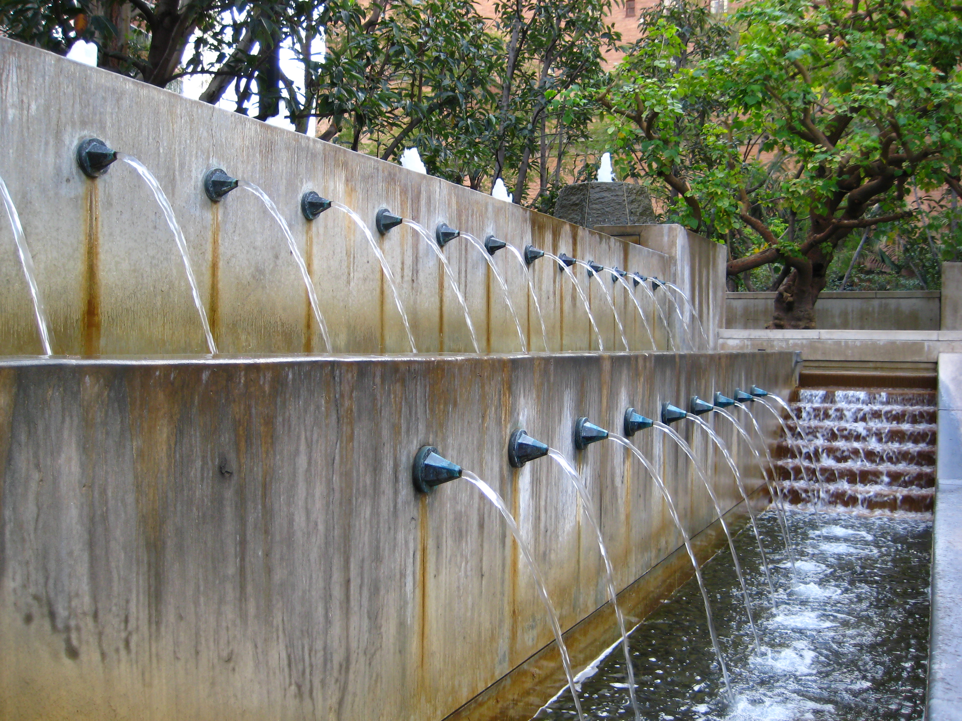 rust stains down face of fountain wall caused by poorly designed apout